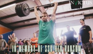 SSG Ben Ransom lifts heavy weight overhead in an Invictus green t-shirt