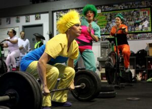 Women dresses as sexy corn, broccoli and carrot doing a team workout.
