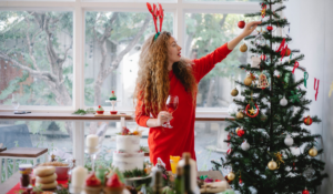 A girl decorating her Christmas tree who has happily stayed on track during the holiday with these tips.