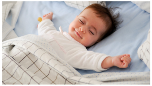 Sleeping baby stretching and smiling.