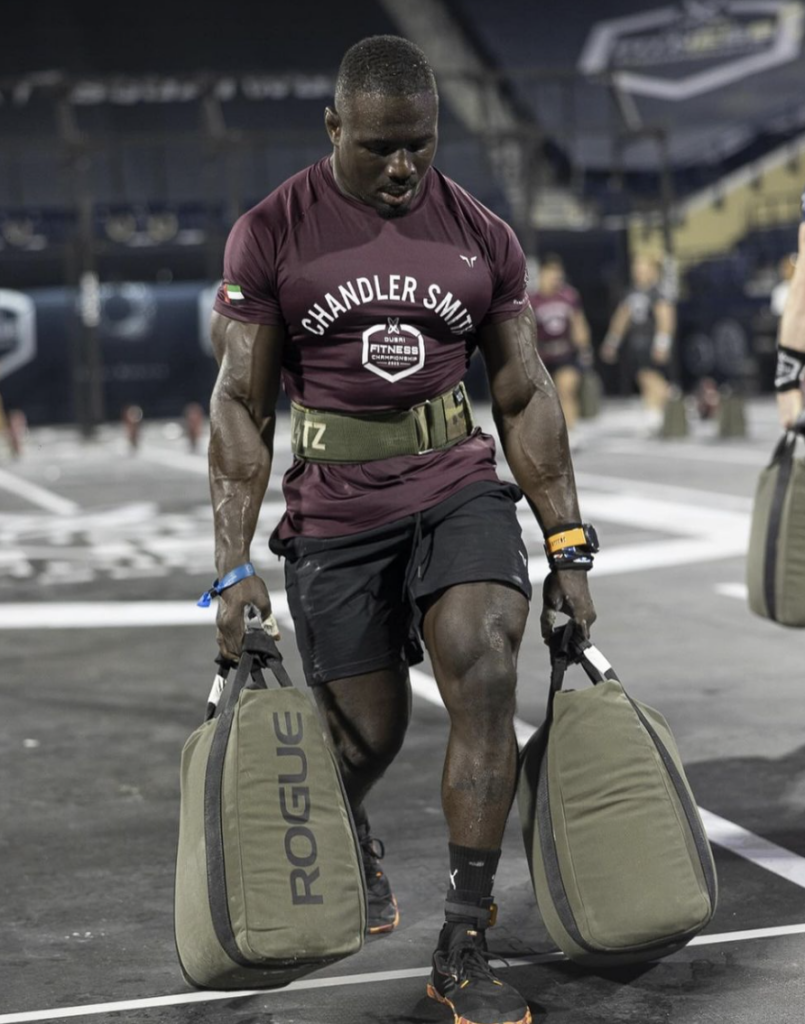 Chandler Smith carries two heavy sandbags at the Dubai Fitness Championship.